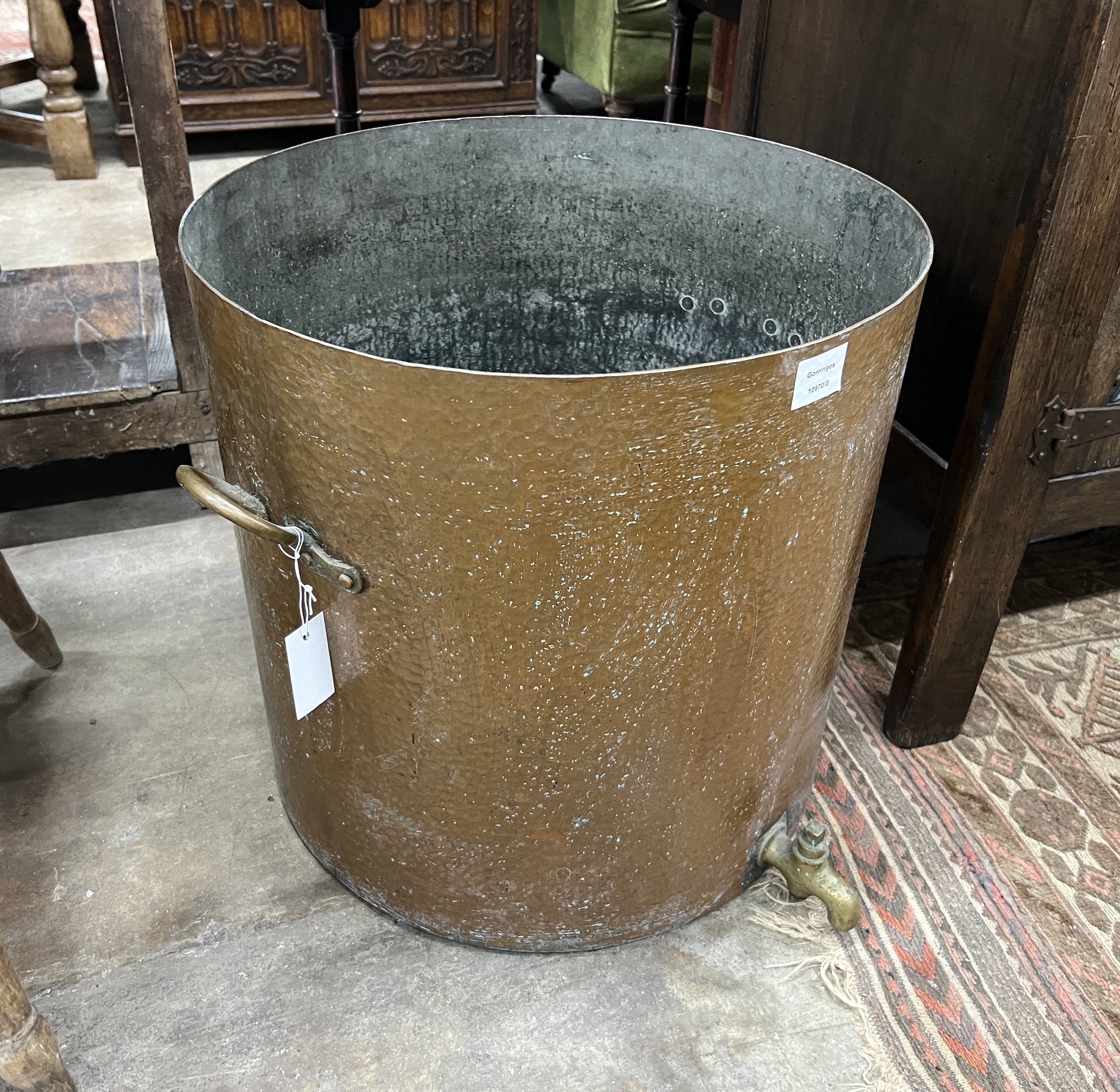 A large Victorian circular hammered copper cauldron with brass spigot, diameter 52cm, height 52cm